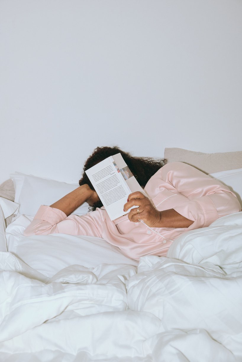 Woman Reading a Book on the Bed