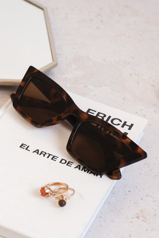 Brown Sunglasses with Book on Marble Background